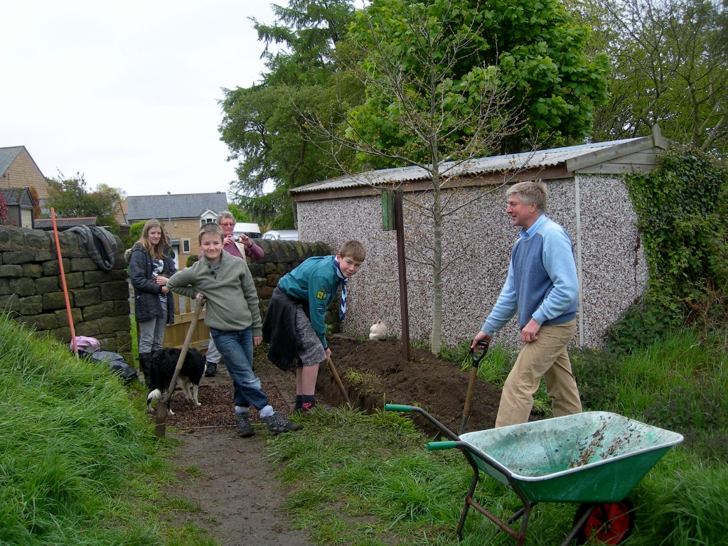 Scout group digging in garden.